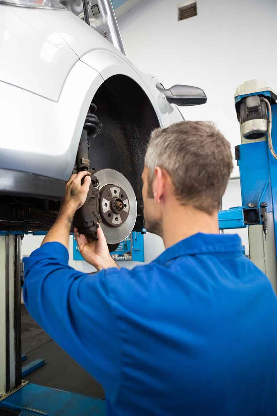 Prüfung einer Fahrzeugbremse mit Bremsscheibe und Bremsbelägen in der Autowerkstatt